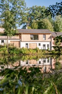 ein Haus mit einer Reflexion im Wasser in der Unterkunft Ferienwohnung Panorama Teichblick in Heldritt