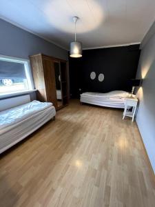 a room with two beds and a table in it at Guesthouse 10 min from Airport. in Njarðvík