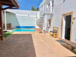 uma casa com piscina ao lado de um edifício em Villa Montaña em Balcon de Telde