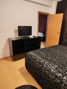 een hotelkamer met een bed en een flatscreen-tv bij Апартамент "Red&Black" в Гранд Манастира - Пампорово in Pamporovo