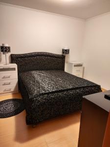 een slaapkamer met een bed en 2 nachtkastjes en een bureau bij Апартамент "Red&Black" в Гранд Манастира - Пампорово in Pamporovo