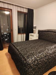 een slaapkamer met een groot bed en een raam bij Апартамент "Red&Black" в Гранд Манастира - Пампорово in Pamporovo