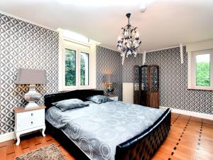 a bedroom with a bed and a chandelier at Luxurious castle with hot tub in the Belgian in Jamoigne