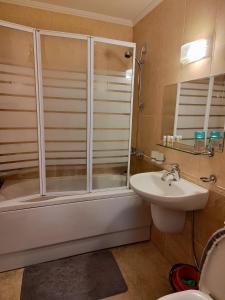 een badkamer met een douche en een wastafel bij Апартамент "Red&Black" в Гранд Манастира - Пампорово in Pamporovo