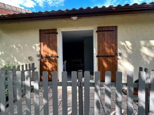 ein weißer Gartenzaun vor einem Haus in der Unterkunft Studio avec terrasse privative in Pessac