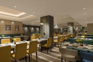 um restaurante com mesas e cadeiras e um bar em Grand Mercure Agra - An Accor Brand em Agra