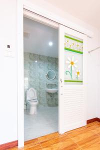 a bathroom with a toilet and a sliding door at โรงแรมเชียงคำรักคุณ in Chiang Kham