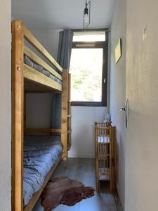 UvernetにあるPra Chauvet - Appartement 5 personnes Praloupの二段ベッド2台と窓のある寝室