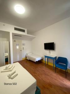 帕利努罗Il Gabbiano Palinuro的一间有床、桌子和电视的房间