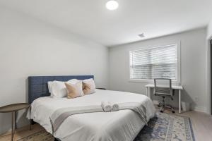 een slaapkamer met een bed, een bureau en een raam bij West Taylor Run Hotel in Alexandria