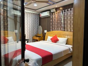 a bedroom with a bed with red pillows at STAYMAKER DV Residency in Bhadrāvati