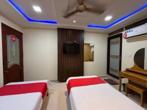 una habitación de hotel con 2 camas y un piano en STAYMAKER DV Residency, en Bhadrāvati