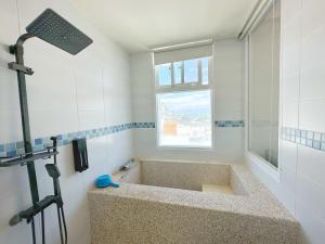 a bathroom with a large bath tub with a window at Good Viewing Spot B&B in Green Island