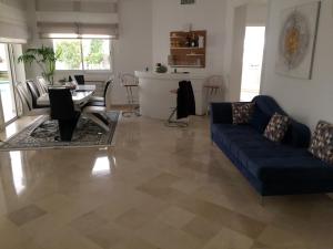 Villa Gammarth - Suite N°2 في قمرت: غرفة معيشة مع أريكة زرقاء وطاولة