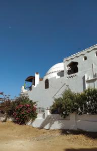 a white building with flowers in front of it at Nubian Holiday House Aswan in Aswan