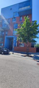 a tree on the side of a street in front of a building at Aurora Home Kivistö 1-bedroom apartment for up to 8 near Helsinki Vantaa Airport and Helsinki city center in Vantaa +7 photos