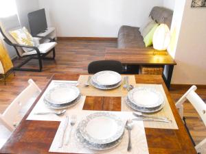 una mesa de comedor con platos y cubiertos en Naturalia: La casita con Patio, en Cáceres