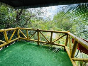 a wooden railing on a balcony with a green floor at Lakefront Tree Escape in Buriram, Thailand in Buriram