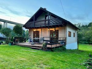 een klein huis met een veranda en een terras bij Blockhaus Ourtal in Winterspelt