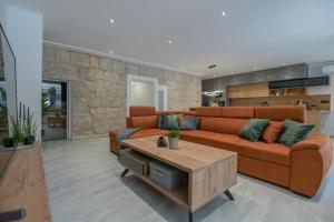 ein Wohnzimmer mit einem orangenen Sofa und einem Couchtisch in der Unterkunft Villa Erwin with heated pool in Imotski