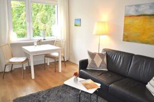 ein Wohnzimmer mit einem Sofa und einem Tisch in der Unterkunft App 44 Seestern Ferienwohnung in Timmendorfer Strand