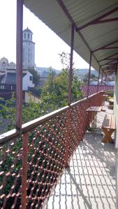 eine Terrasse mit einem Zaun und Bänken an einem Gebäude in der Unterkunft Coffee Hostel in Lwiw