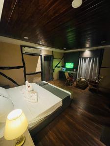 1 dormitorio con 1 cama y TV. en Daosri The Inn, en Jyoti Gaon