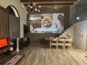 a living room with a table and a cat on a poster at 青逸居 桃園中壢民宿 親子包棟 Qing Yi Ju in Zhongli