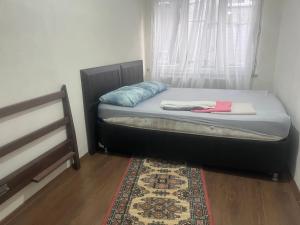 a bed in a room with a window and a rug at Fatih Eco 3 Apart in Istanbul