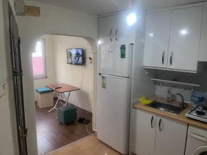 a kitchen with a white refrigerator and a table at Fatih Eco 3 Apart in Istanbul