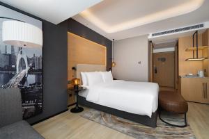 Rúm í herbergi á Langham Honor International Hotel Canton Fair Complex Branch - Free Shuttle to Canton Fair Complex During Canton Fair Period & Free Mini Bar