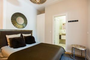 Schlafzimmer mit einem Bett und einem Spiegel an der Wand in der Unterkunft Apartments of the Marques in Lissabon