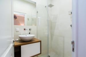 ein Bad mit einem Waschbecken und einer Glasdusche in der Unterkunft Apartments of the Marques in Lissabon