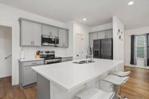 a kitchen with white cabinets and a white counter top at Heads or Tails - LSU in Baton Rouge