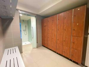 a bathroom with wooden lockers and a shower at Piso de lujo con piscina y gym, a 2min de la playa in A Coruña +7 photos