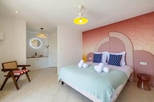 - une chambre avec un grand lit et un mur rose dans l'établissement Sumptuous B&B Villa Provençale - 2BR4p, à Grimaud