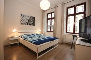 a bedroom with a bed and a flat screen tv at Pension Alba in Görlitz