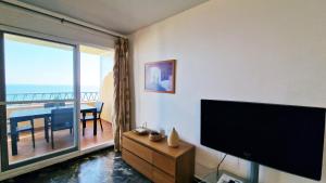 a living room with a flat screen tv and a dining table at AA Guest - Don Juan Eco Front Sea Views Apartment in Fuengirola