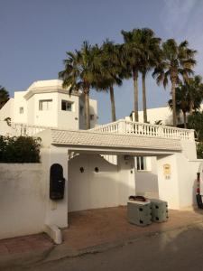a white house with palm trees in the background at Villa Gammarth - Chambre N°4 in Gammarth