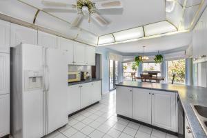 a white kitchen with white cabinets and a large island at Markham private room in Markham