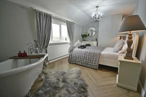 1 dormitorio con cama, lavabo y espejo en Pendle Hill Farm - 5* Luxury, Log fire, Parking, en Burnley