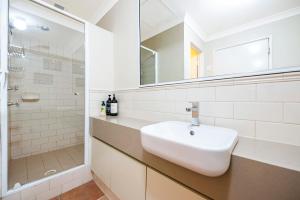 Un baño blanco con lavabo y ducha. en Ocean Sunsets - 2 bedroom converted warehouse apartment, en Fremantle 25 fotos más