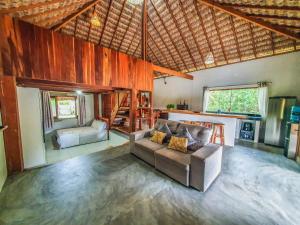 a living room with a couch and a kitchen at Pousada NAK - Nativa Arpoador Kite in Tutóia