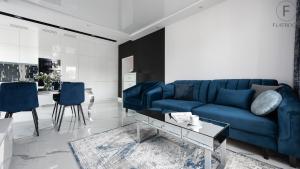 a living room with a blue couch and a table at Flatbook - City Center Apartments Monte Cassino in Sopot