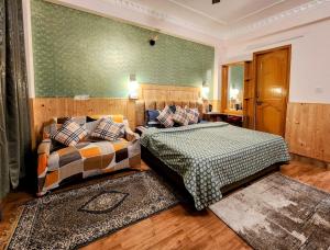 1 dormitorio con 2 camas y pared verde en The Bougainvillea, Mcleodganj, en Dharamshala