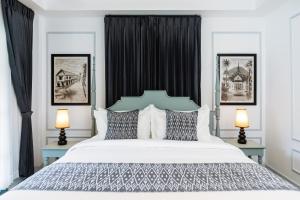a bedroom with a large white bed with two lamps at Luangprabang D'or Boutique Hotel in Luang Prabang +41 photos