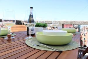 un tavolo con ciotola e bicchieri da vino sul balcone di Apartment with terrace in Chioggia's main square a Chioggia