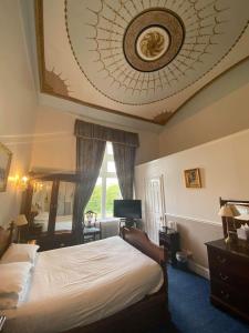 a bedroom with a bed and a ceiling with a clock at Cave Castle Hotel in South Cave