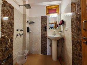 y baño con lavabo y ducha. en The Bougainvillea, Mcleodganj, en Dharamshala