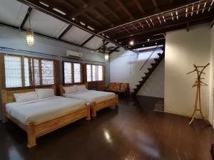a bedroom with two beds and a staircase at Mori Jonker in Malacca